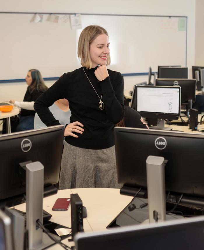 professor works with students in the computer lab.